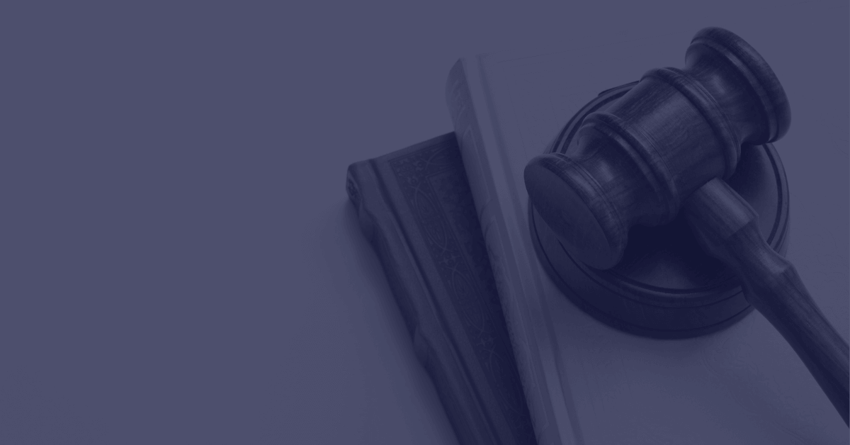 Maillet de juge posé sur deux livres de droit, photographie teintée de bleu nuit